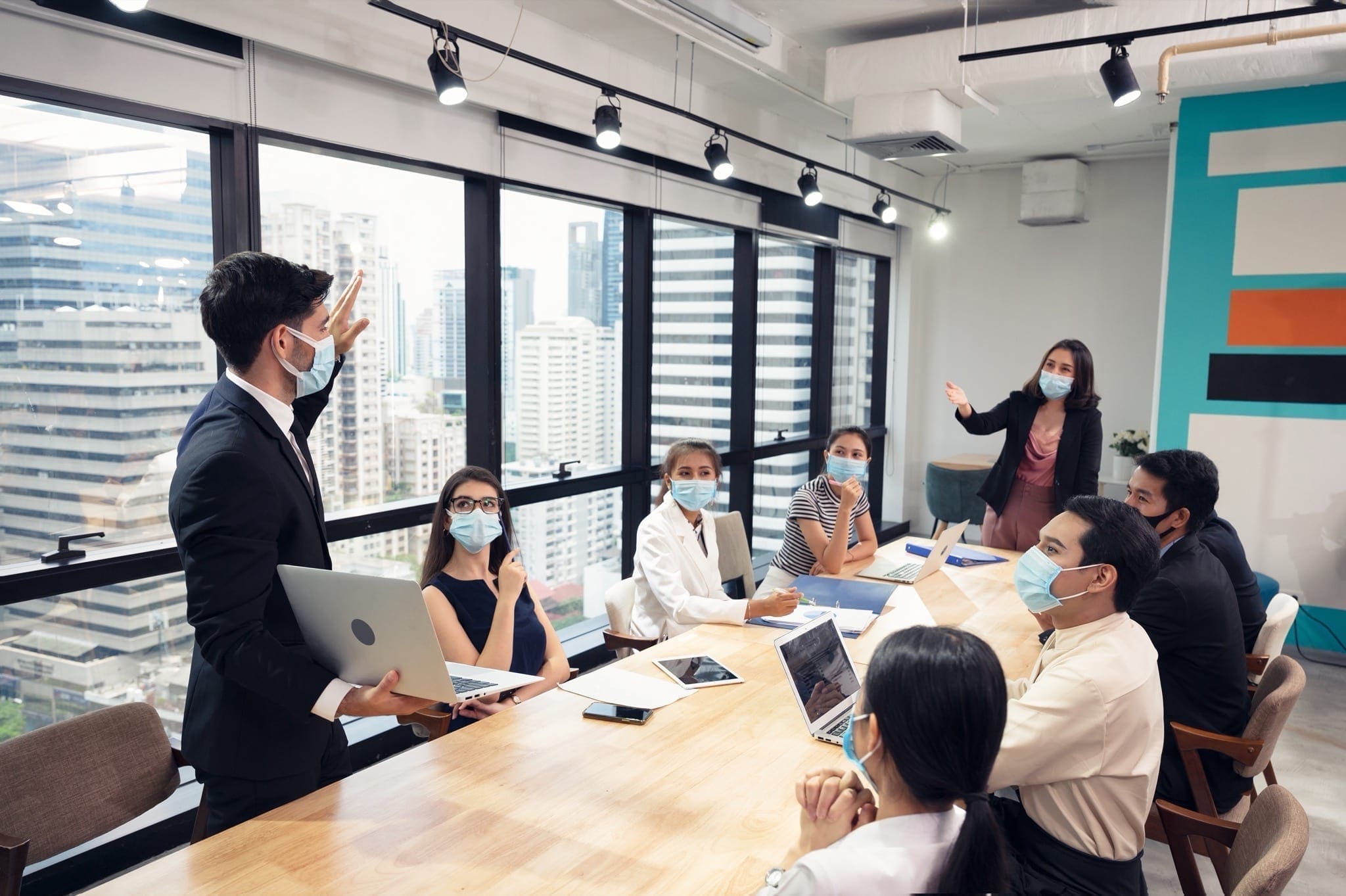 businessman wearing face mask with presentation business plan laptop copy - Businessman wearing face mask with presentation of business plan on laptop, corporate business meeting in modern office